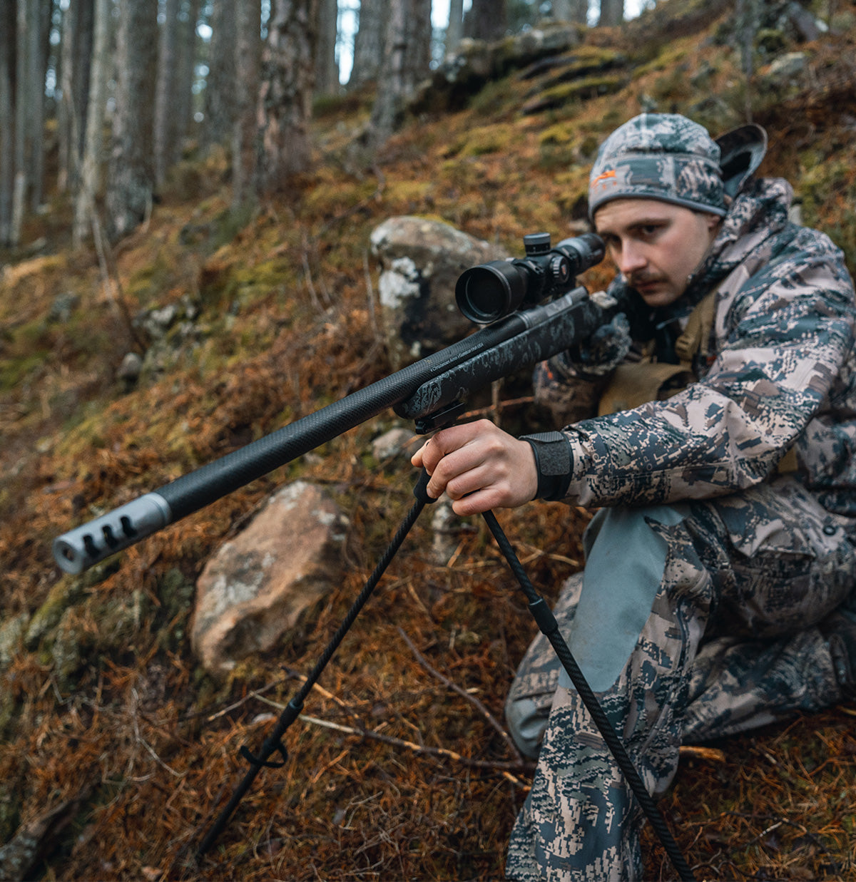 ELITE Spartan Springbok bipod mounted on a rifle, showcasing its sturdy black metal construction and adjustable legs.