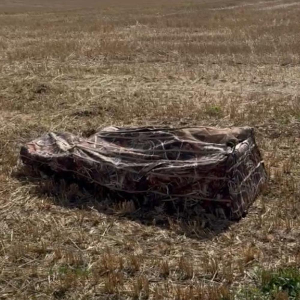 DALE pop-up wildfowl stubble camo lay-down ground blind set up in a natural outdoor setting for hunting concealment.