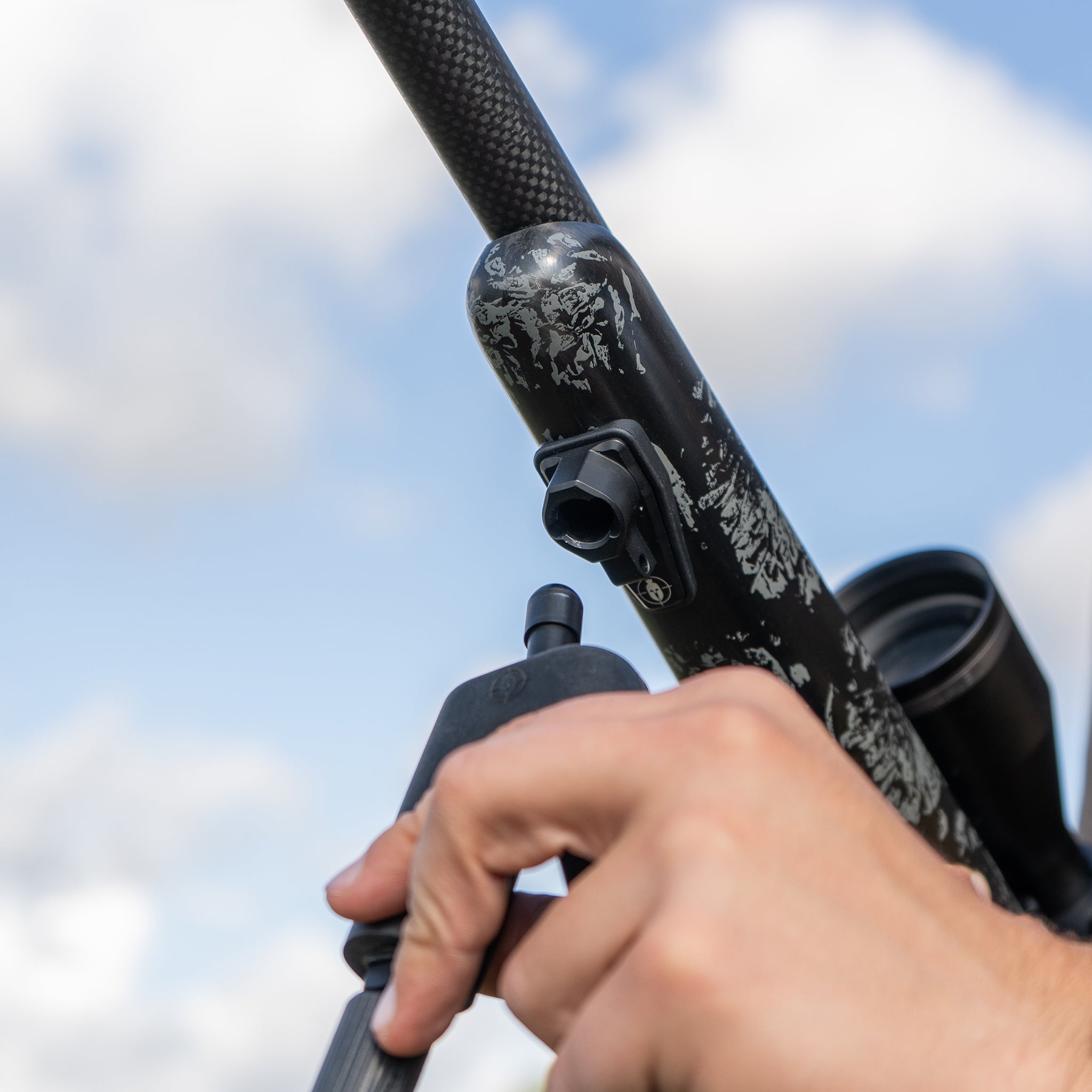 ELITE Spartan Springbok bipod for rifles, black metal with adjustable legs, mounted on a firearm for stability during shooting.