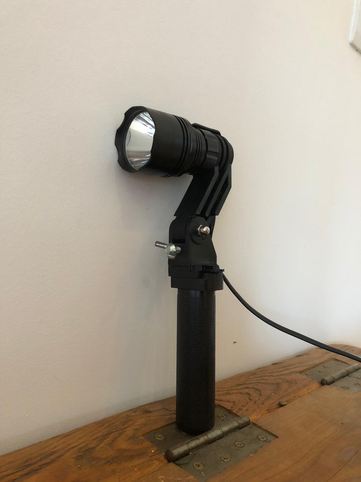 A1 Decoy LED handheld and scope-mounted lamp with 300m+ beam distance, shown in use for outdoor or tactical illumination.