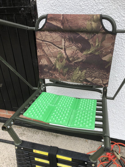 Green waterproof padded folding cushion for high seats or hunting, provides comfort and support during outdoor activities.