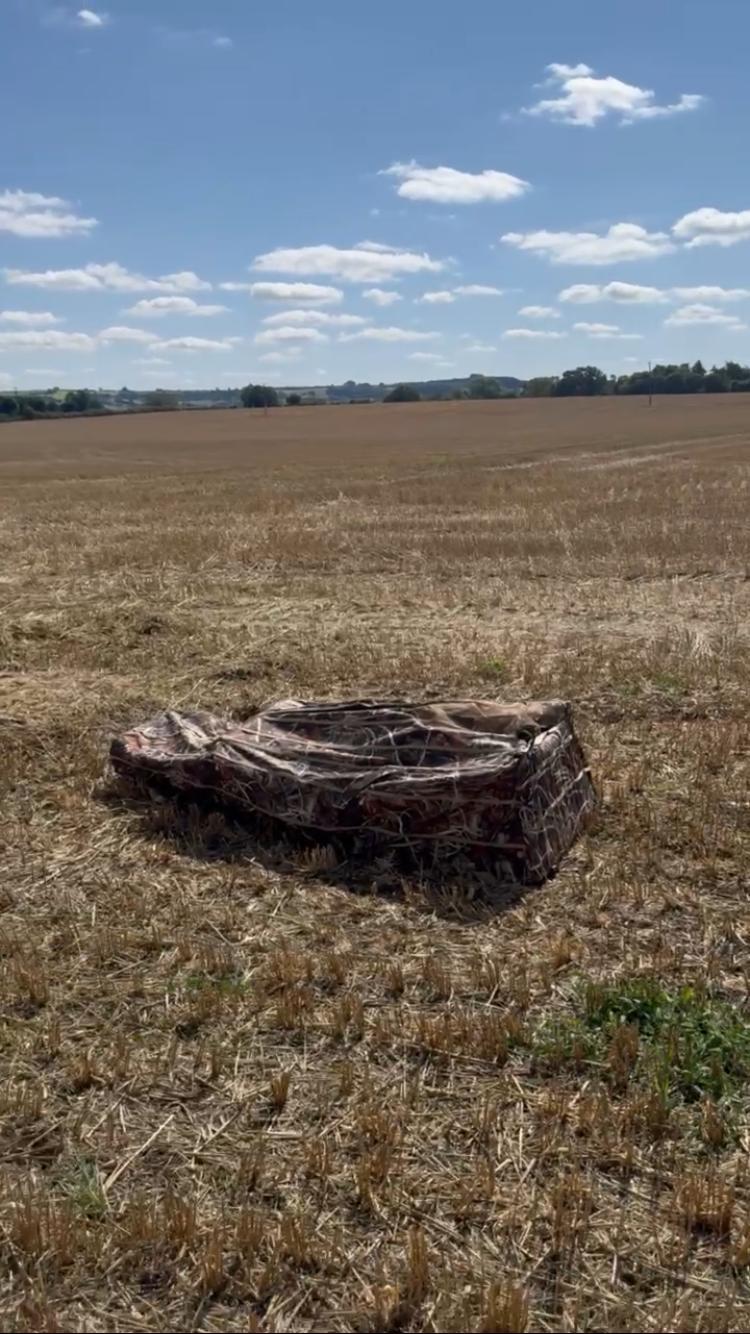 DALE Pop Up Wildfowl Stubble Camo Lay Down Ground Blind set up in a field, designed for hunting and concealment.
