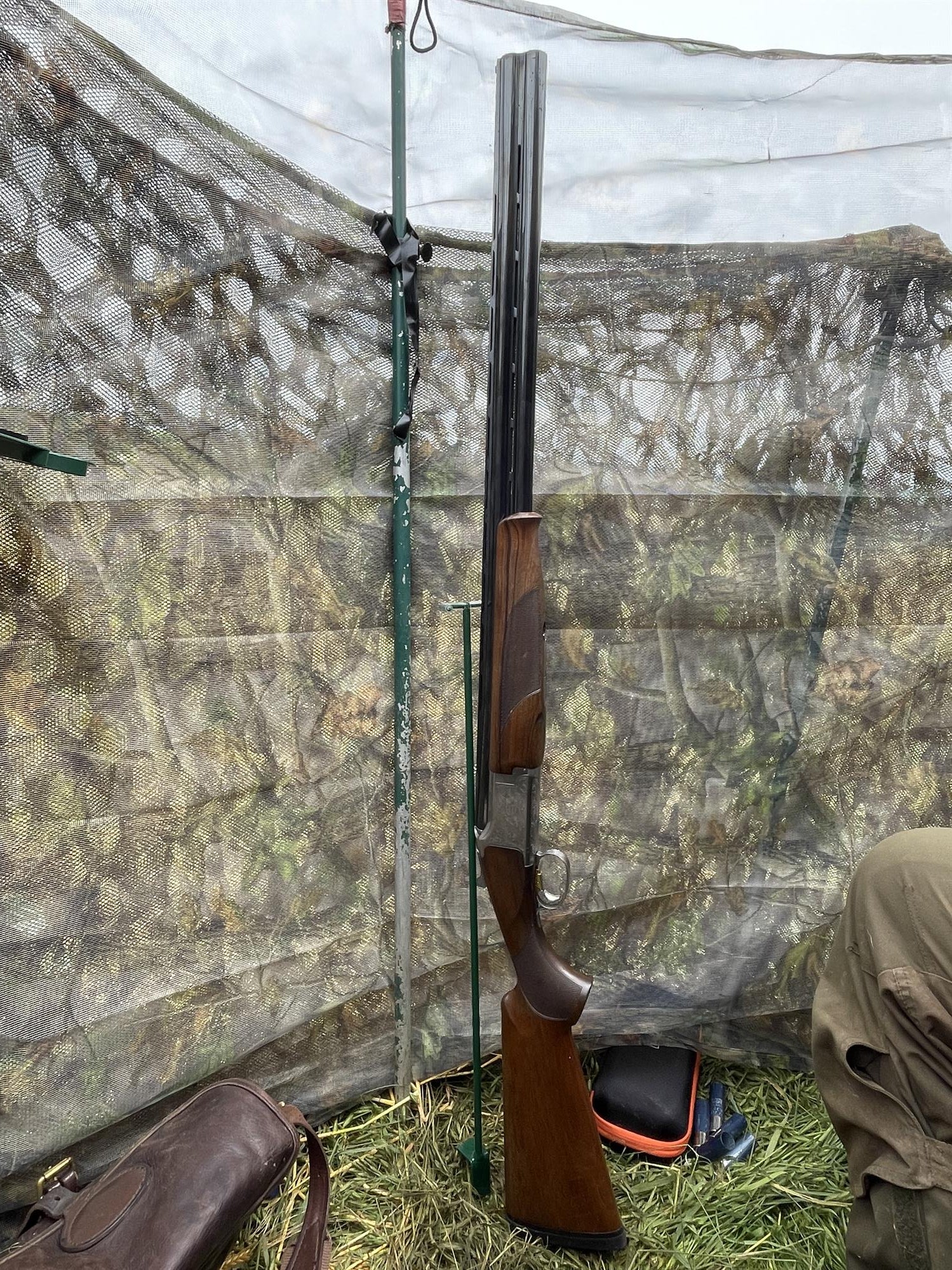 Echo gun stand for hunting hide, sturdy black metal support for securing rifles and gear in outdoor hunting setups.