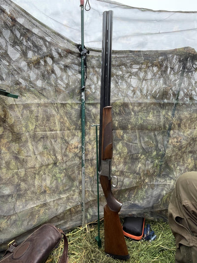 Echo gun stand for hunting hide, sturdy black metal support for securing rifles and gear in outdoor hunting setups.