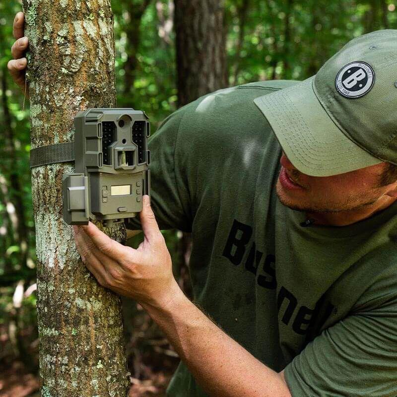 EDGAR Bushnell 20MP Prime L20 Low Glow Trail Camera mounted in a wooded area, capturing wildlife with low glow infrared flash.