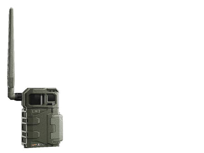 TJACKS SPYPOINT LM2 trail camera mounted outdoors, showing its compact design and lens for wildlife surveillance.